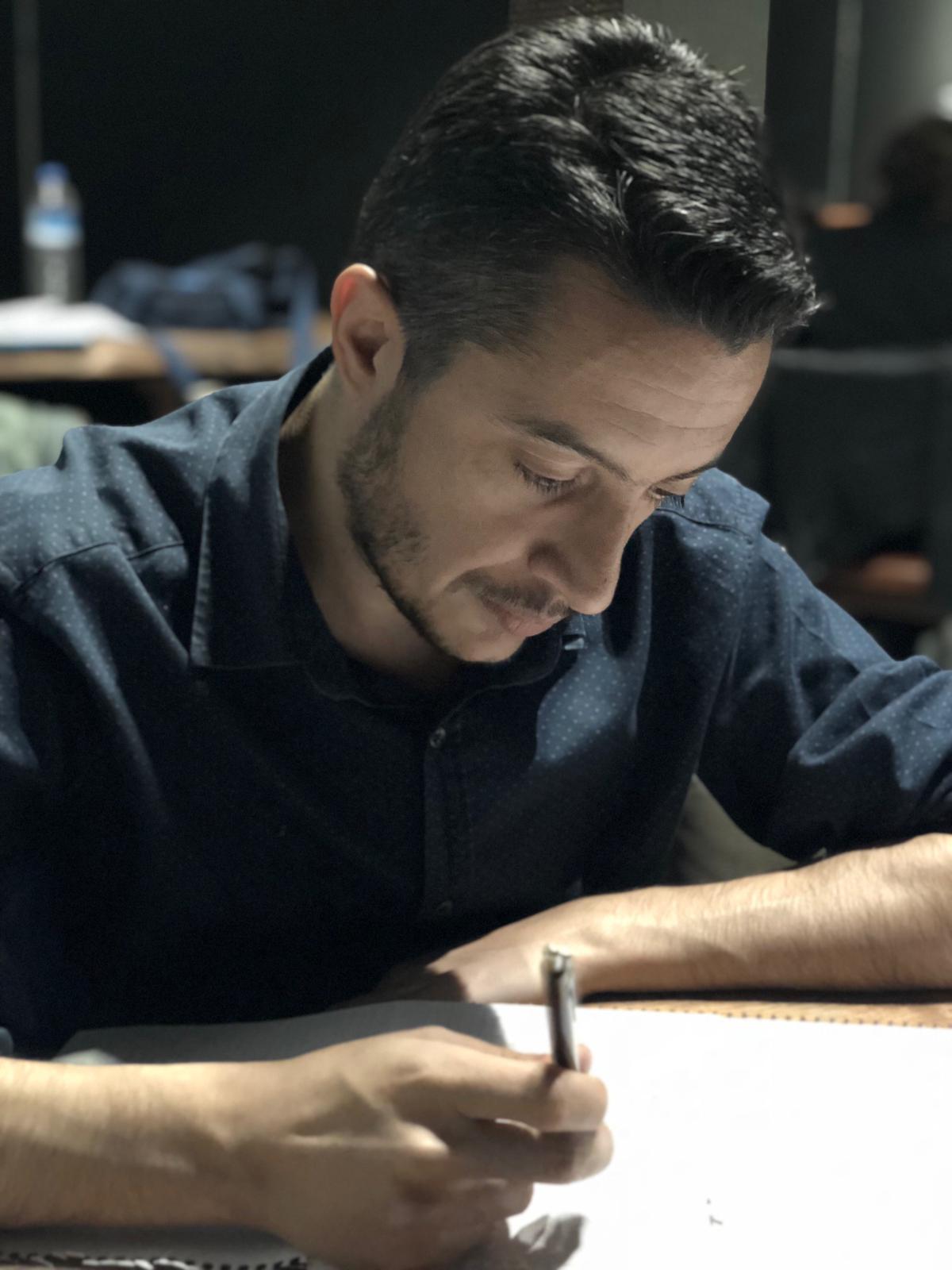 Nurettin Dönmez çalışma masasında not alırken